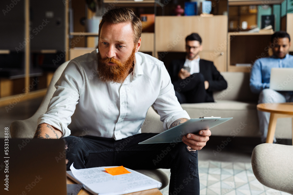 © Drobot Dean - Businessman with his colleagues on a background working on laptop in office © Drobot Dean - Businessman with his colleagues on a background working on laptop in office