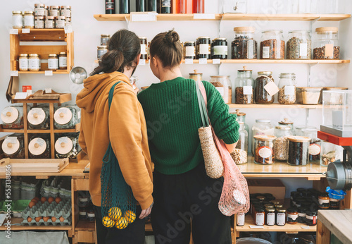 Couple with mesh bags shopping in zero waste store photo