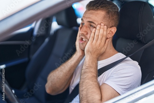 Young caucasian man stressed driving car at street