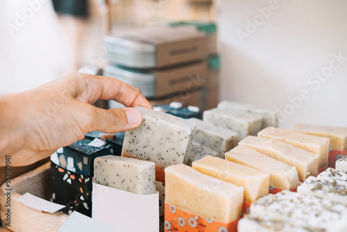 Woman picking scented soap bar at zero waste shop photo
