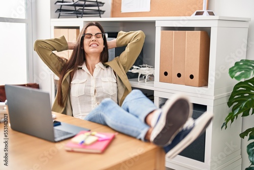 Young beautiful hispanic woman business worker relaxed with hands on head at office