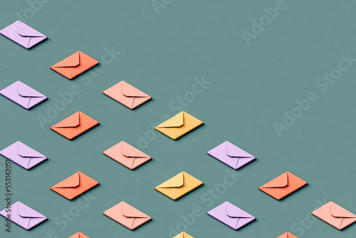 Three dimensional render of rows of pastel colored envelopes flat laid against green background photo