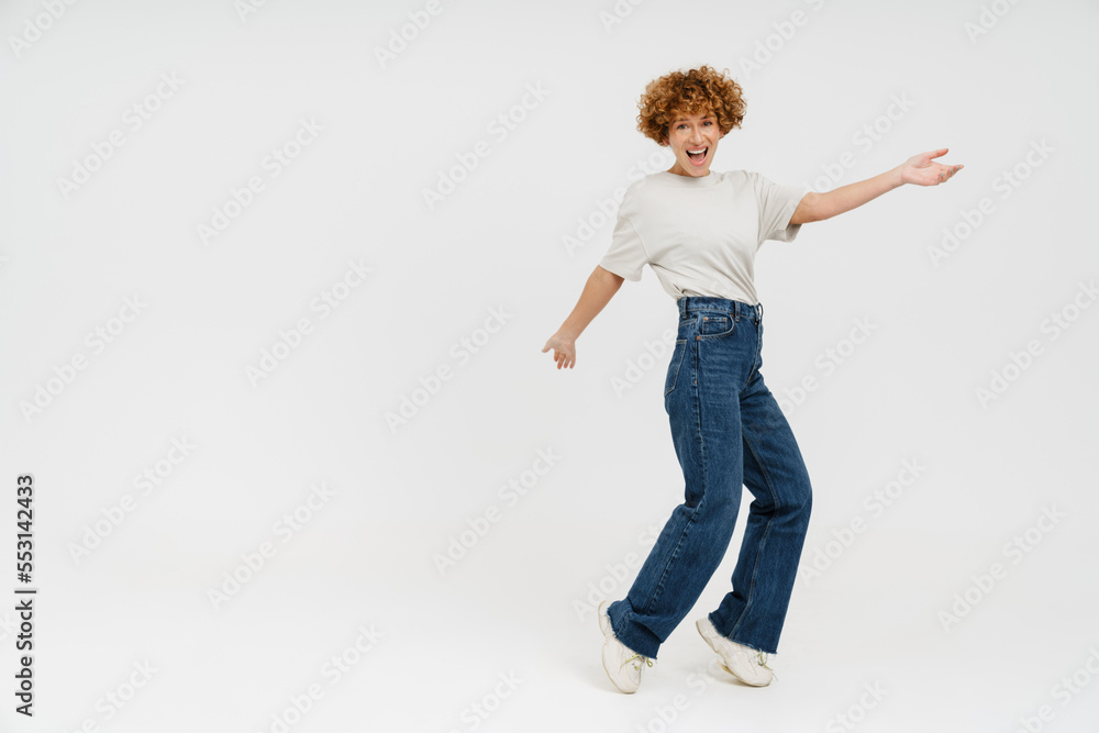 Ginger curly woman wearing t-shirt smiling and dancing Ginger curly woman wearing t-shirt smiling and dancing