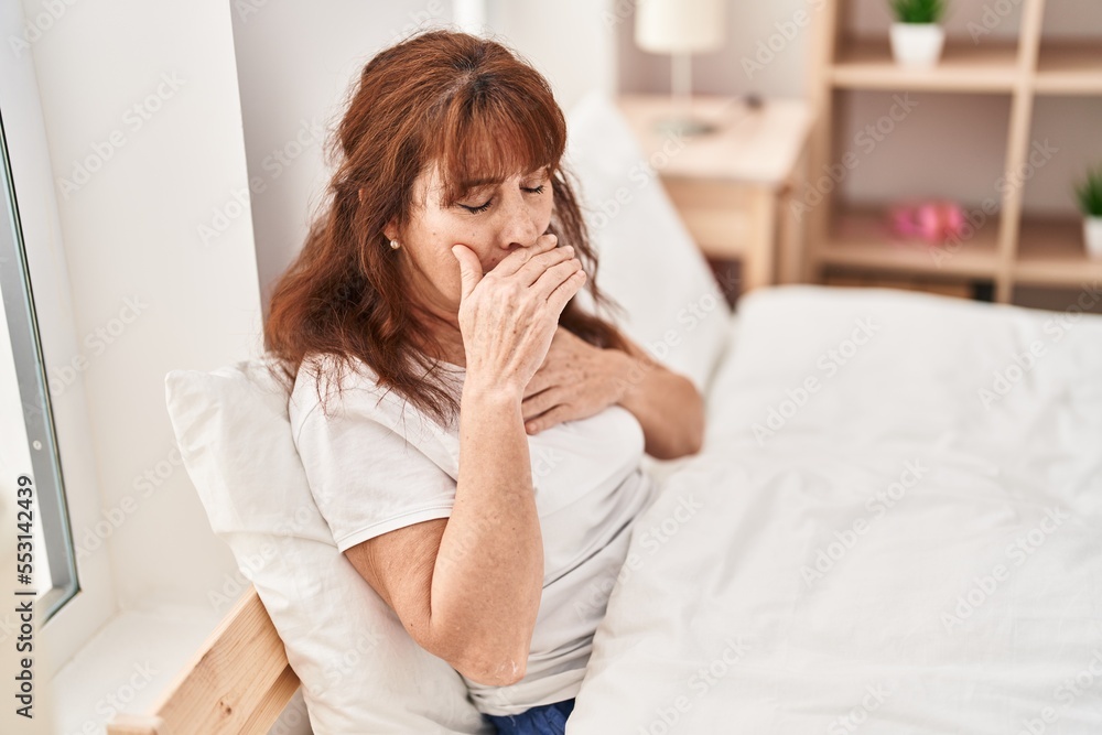 Middle age woman coughing sitting on bed at bedroom Middle age woman coughing sitting on bed at bedroom