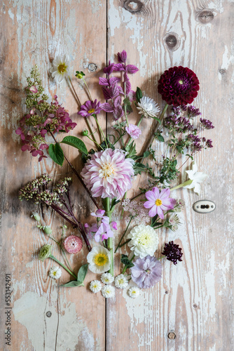 Various flowers flat laid against wooden surface photo