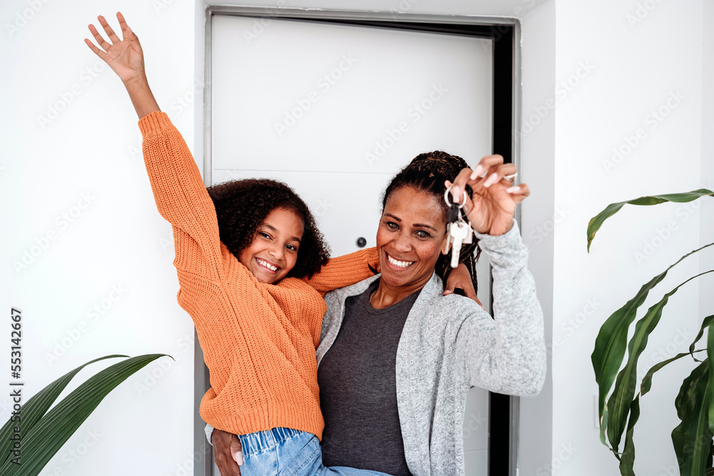 © Westend61 - Happy girl with mother holding keys of new house