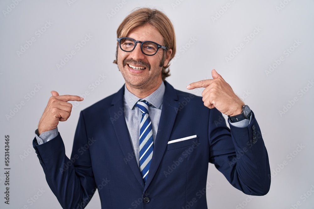 Caucasian man with mustache wearing business clothes looking confident with smile on face, pointing oneself with fingers proud and happy. Caucasian man with mustache wearing business clothes looking confident with smile on face, pointing oneself with fingers proud and happy.