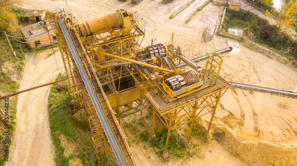 Aerial view on the rubber conveyor belt of an industrial tool. Aggregate crushing and sorting plant. Industry closeup.