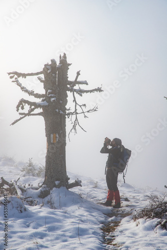 man trekking in foggy winter landscape in the mountains © Melinda Nagy