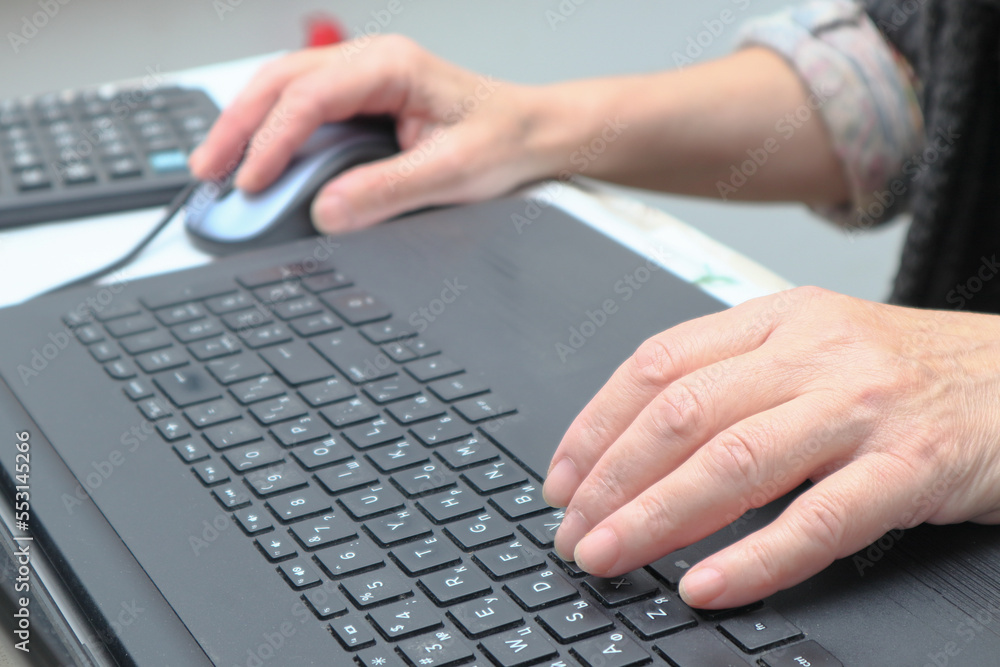 Old Woman working at home office hand on keyboard close up. Close up of woman hands typing on laptop. Old Woman working at home office hand on keyboard close up. Close up of woman hands typing on laptop.