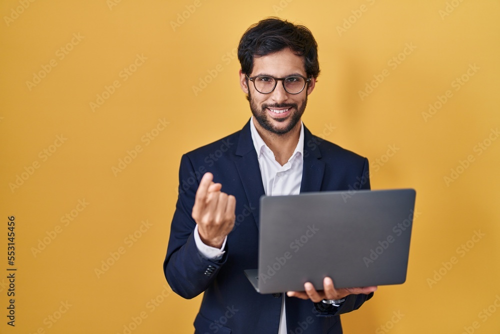 Handsome latin man working using computer laptop beckoning come here gesture with hand inviting welcoming happy and smiling Handsome latin man working using computer laptop beckoning come here gesture with hand inviting welcoming happy and smiling