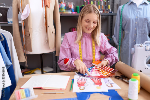 Young blonde woman tailor smiling confident holding color test at tailor shop