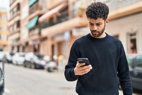Young arab man using smartphone at street
