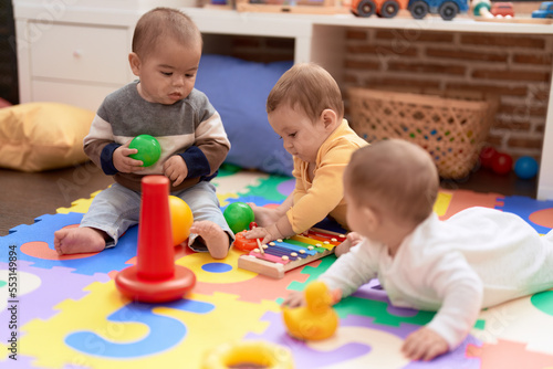 Fényképezés Group of toddlers playing with toys sitting on floor at kindergarten