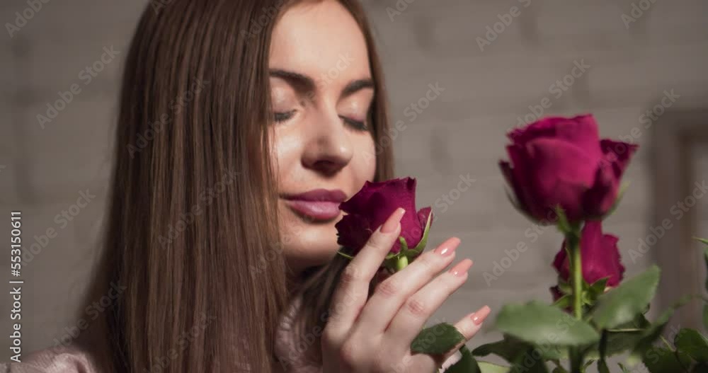 Young attractive woman smelling a bouquet of roses . Close up shot. Young attractive woman smelling a bouquet of roses . Close up shot.
