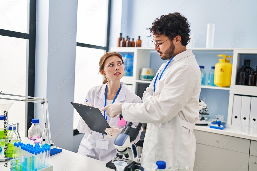 Fototapeta premium Man and woman scientist partners working at laboratory