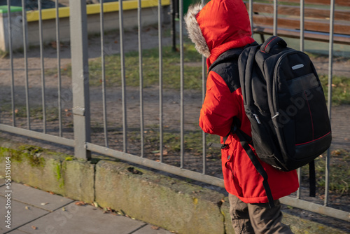 Boy goes to school with backpack on his back.