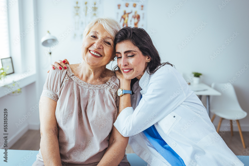 Young care specialist is sitting beside granny and hugging her. Old woman is bit scared and lonely so she is getting needed comforting. Caring young medical doctor hugging patient.