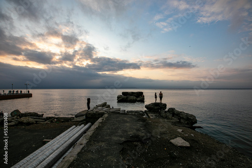 Sports embankment of Vladivostok. Broken pier going into the sea during sunset.