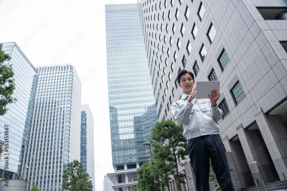 タブレットを持つ作業服の男性 タブレットを持つ作業服の男性