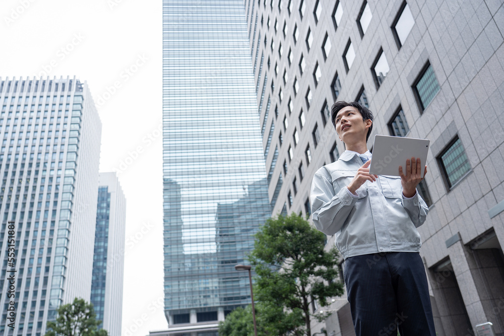 タブレットを持つ作業服の男性 タブレットを持つ作業服の男性