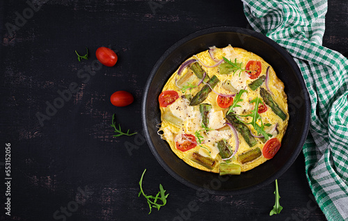 Healthy asparagus omelette. Eggs omelet with asparagus, tomatoes, and cheese. Top view, overhead