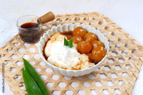 Bubur Sumsum Biji Salak or bubur Candil, Indonesian rice flour porridge with sweet potato glutinous rice balls, served with palm sugar sauce  photo