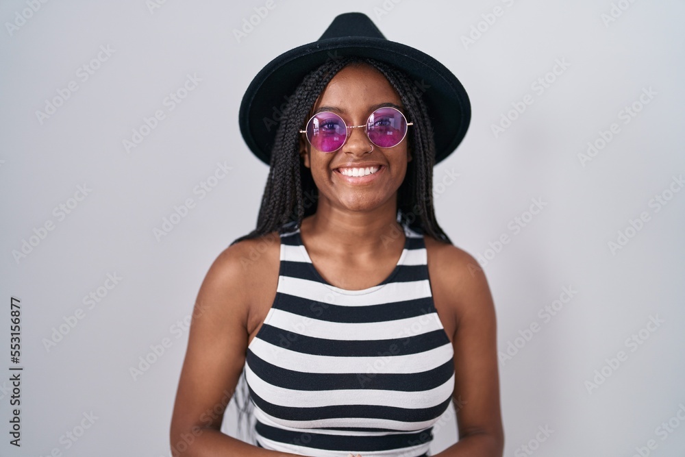 Young african american with braids wearing hat and sunglasses with hands together and crossed fingers smiling relaxed and cheerful. success and optimistic Young african american with braids wearing hat and sunglasses with hands together and crossed fingers smiling relaxed and cheerful. success and optimistic