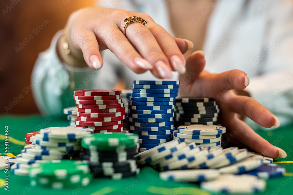 woman in a casino with chips that she wraps after a big win in casino poker. woman in a casino with chips that she wraps after a big win in casino poker.