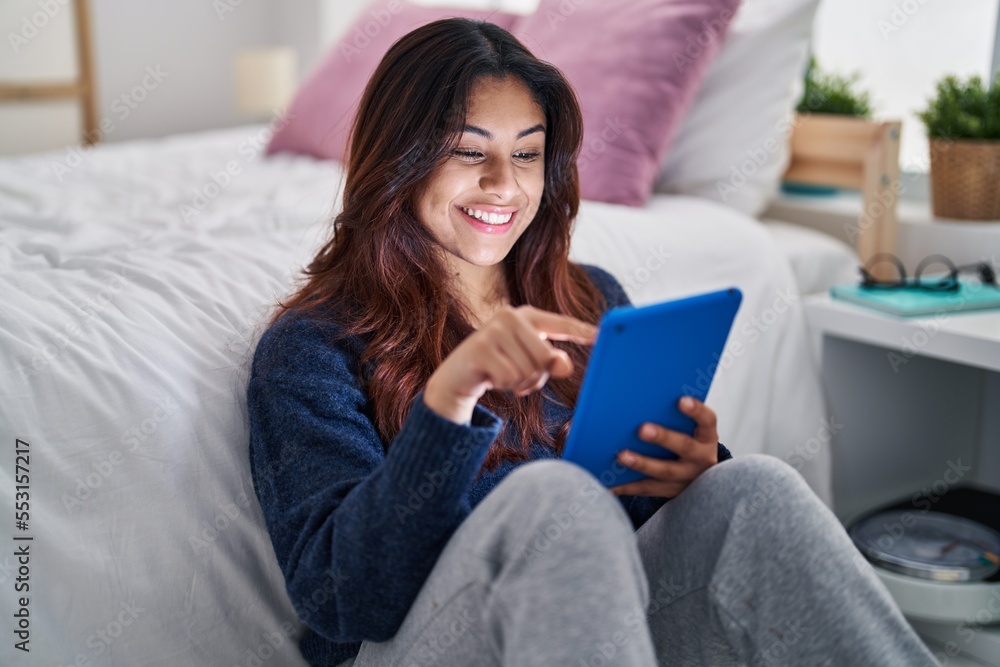 Young hispanic woman using touchpad sitting on floor at bedroom Young hispanic woman using touchpad sitting on floor at bedroom