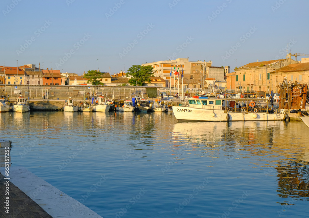 Senigallia, Italy: Boats in the port during sunrise. Senigallia marina across buildings. Canal in Senigallia