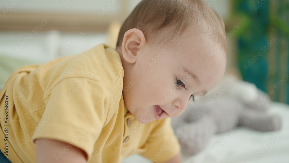 Adorable hispanic baby crawling on bed with relaxed expression at bedroom Adorable hispanic baby crawling on bed with relaxed expression at bedroom