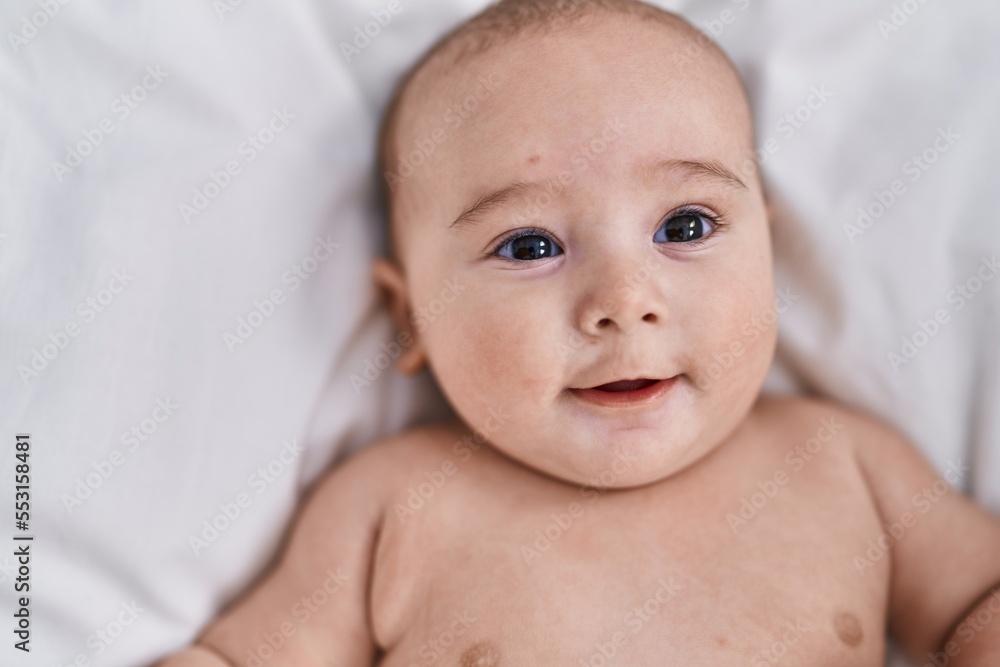 Adorable baby smiling confident lying on bed at bedroom Adorable baby smiling confident lying on bed at bedroom