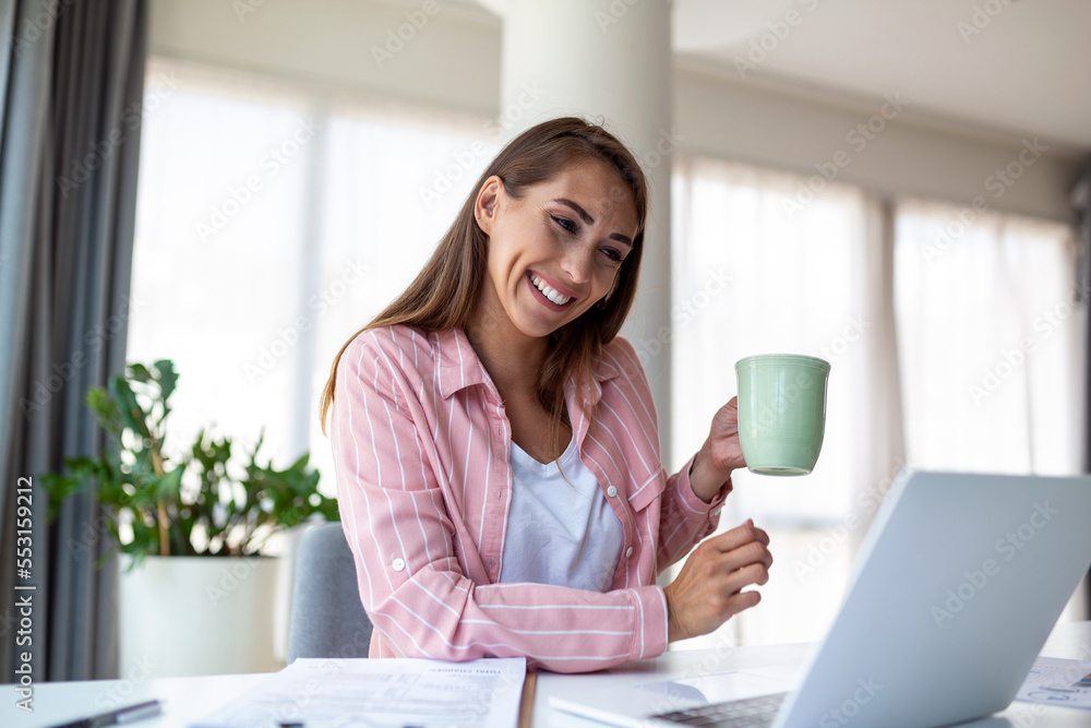 Young business women in the office drinking coffe and looking through a window Young business women in the office drinking coffe and looking through a window