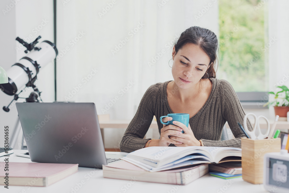 Student doing homework and drinking coffee Student doing homework and drinking coffee