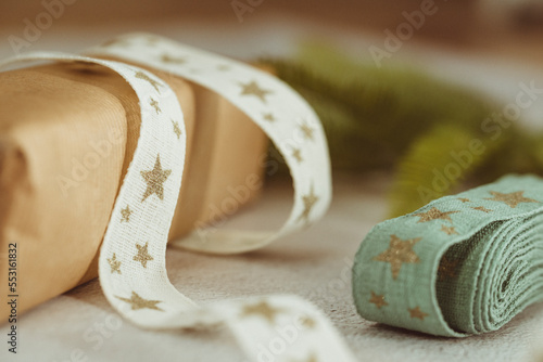 Close-up of wrapped rustic Christmas gifts, ribbon and fir branches photo