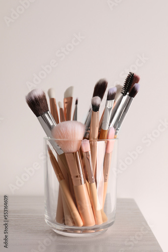 Set of professional brushes on wooden table against white background