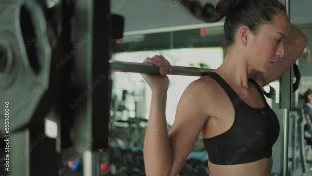 close up of Asian female athlete doing squats in gym with barbell close up of Asian female athlete doing squats in gym with barbell