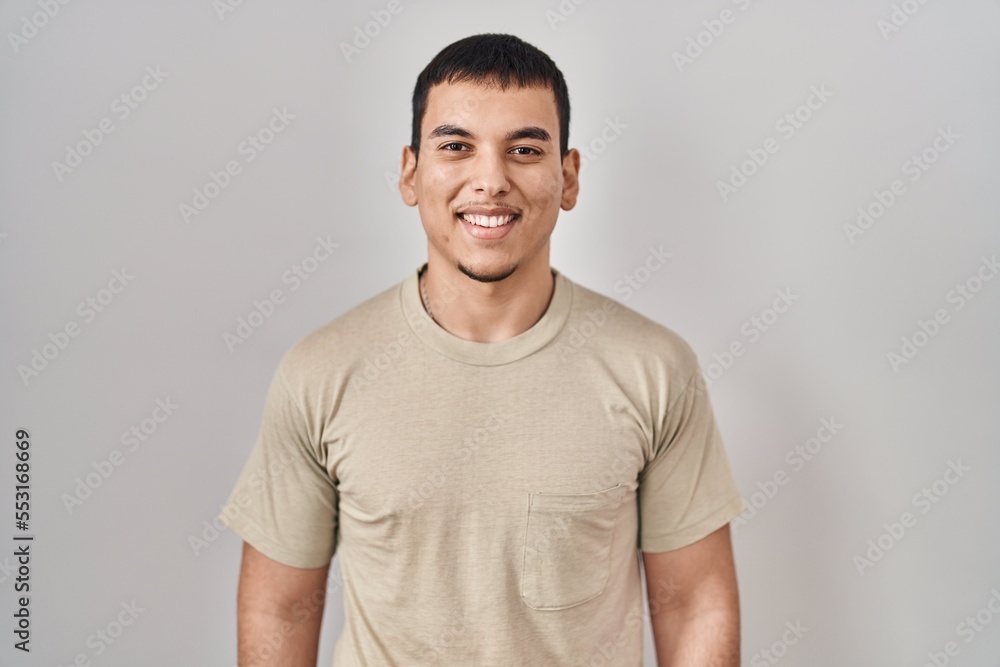 Young arab man wearing casual t shirt with a happy and cool smile on face. lucky person.