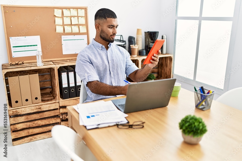 Young middle east man using touchpad and laptop working at office Young middle east man using touchpad and laptop working at office