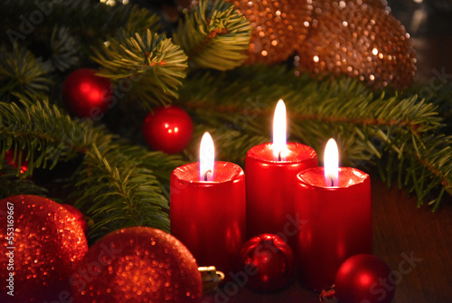 Beautiful christmas decoration with burning red candles and fir tree branch stock images. Burning candles and red Christmas balls still life stock photo. Christmas candle lights background images