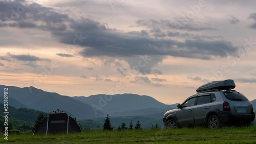 Summer evening landscape timelapse moving clouds Carpathian Mountains, Pryslip pass Ukraine. top of the mountain. A tourist tent and a SUV vehicle with a roof rack. concept of travel by car, Kolochava photo