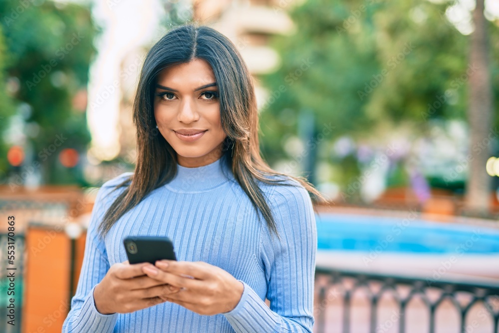 Young hispanic woman using smartphone at the town Young hispanic woman using smartphone at the town