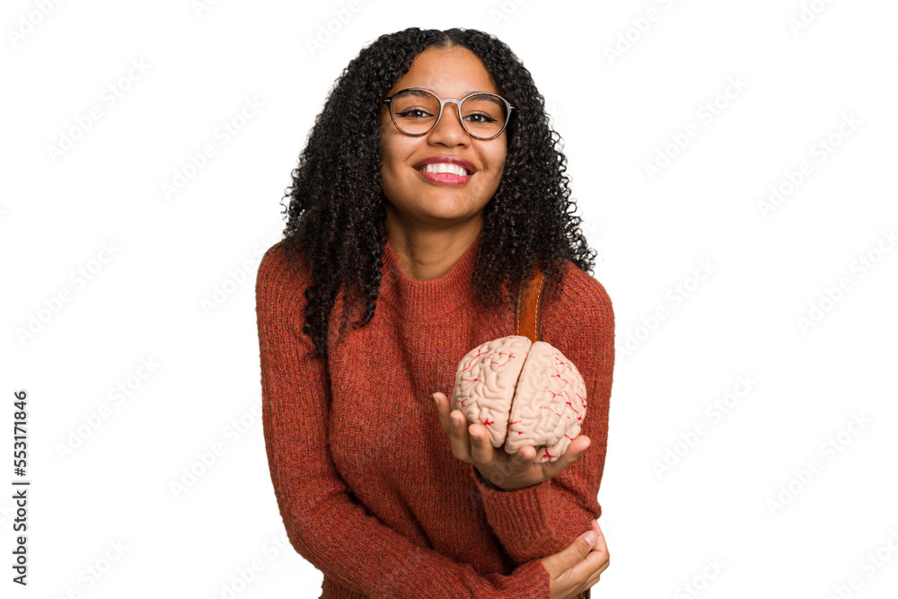 Young student african american woman holding a brain isolated laughing and having fun. Young student african american woman holding a brain isolated laughing and having fun.