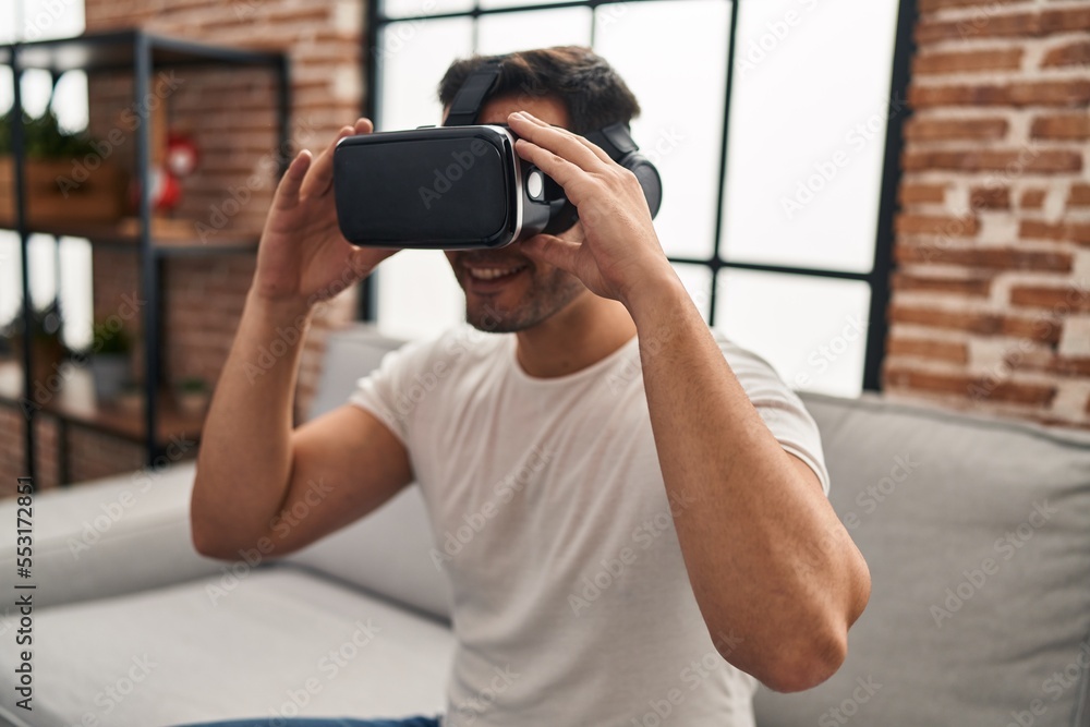 Young hispanic man playing video game using virtual reality glasses at home Young hispanic man playing video game using virtual reality glasses at home