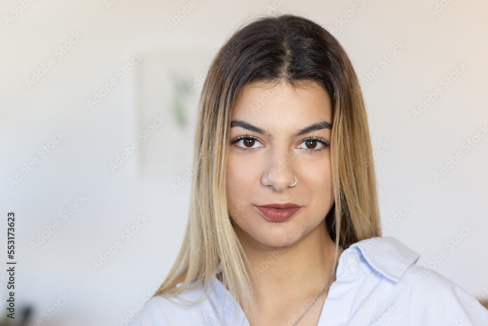 Portrait of attractive young woman in office. Confident Latin woman with nose ring wearing casual shirt looking at camera. Office worker concept Portrait of attractive young woman in office. Confident Latin woman with nose ring wearing casual shirt looking at camera. Office worker concept