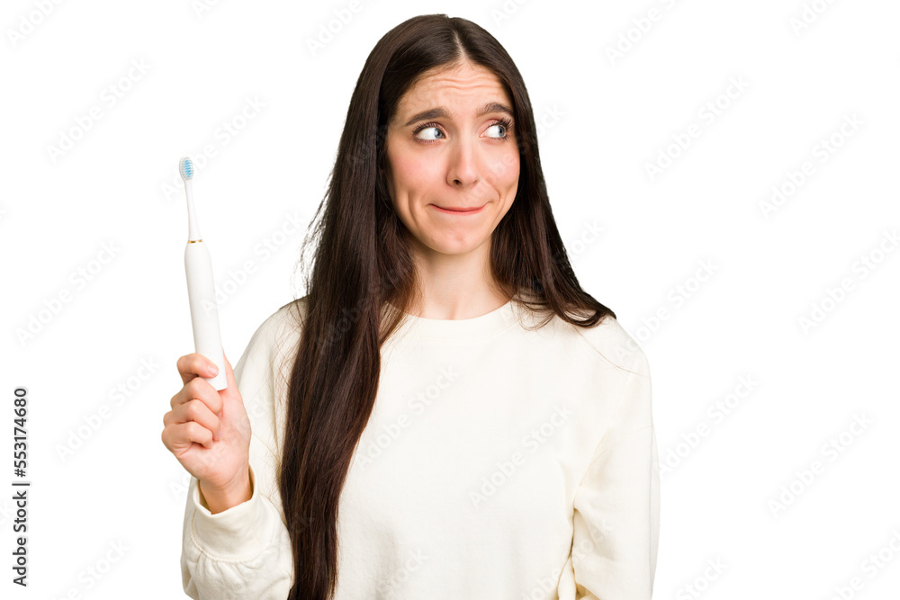 Young caucasian holding a brushing teeth isolated confused, feels doubtful and unsure. Young caucasian holding a brushing teeth isolated confused, feels doubtful and unsure.