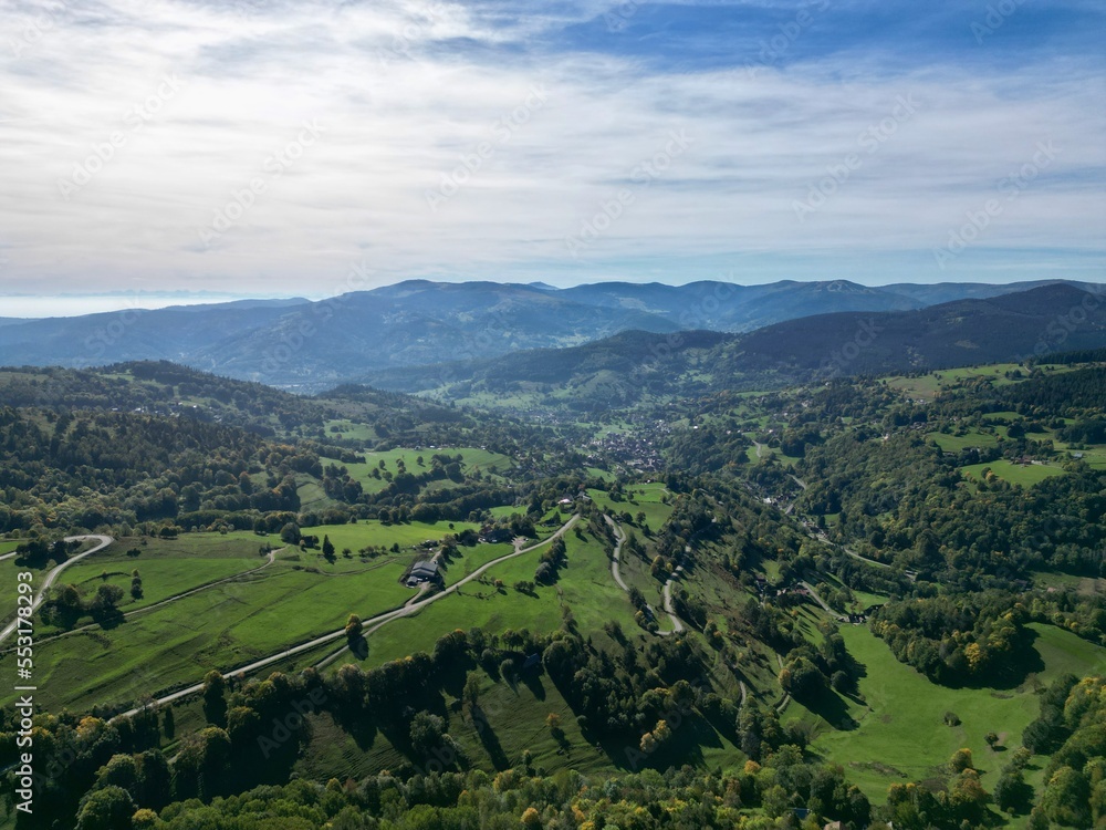 Aerial drone panoramic view on Soultzeren and Stosswihr from the Col de Wettstein and the Musmiss farm-inn in Alsace, by cloudy summer weather, Vosges green forest and mountains in background