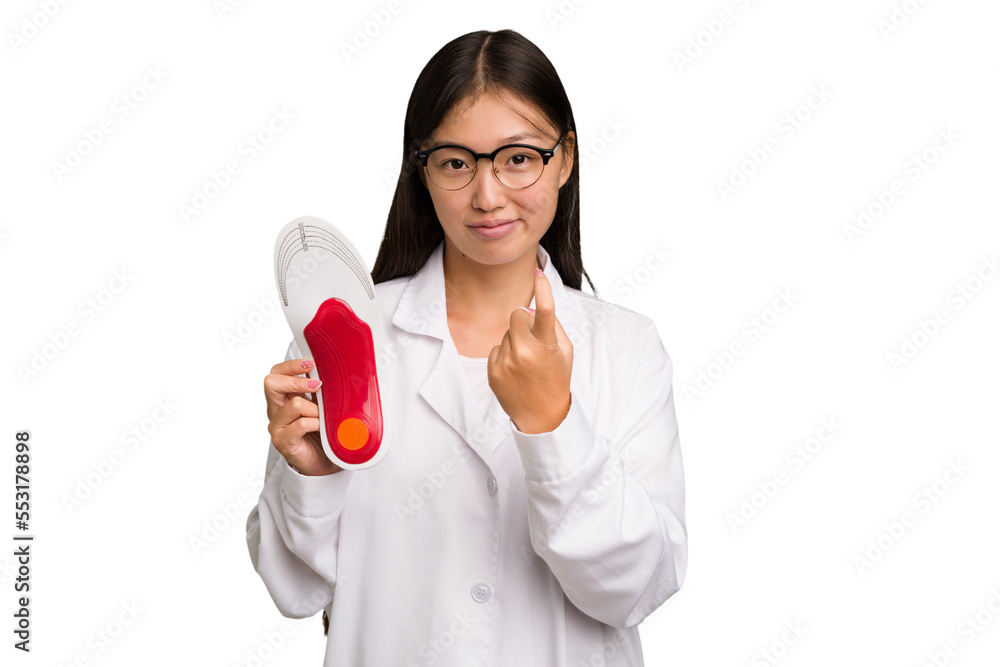 Young asian chiropodist holding a insoles for shoes isolated pointing with finger at you as if inviting come closer. Young asian chiropodist holding a insoles for shoes isolated pointing with finger at you as if inviting come closer.