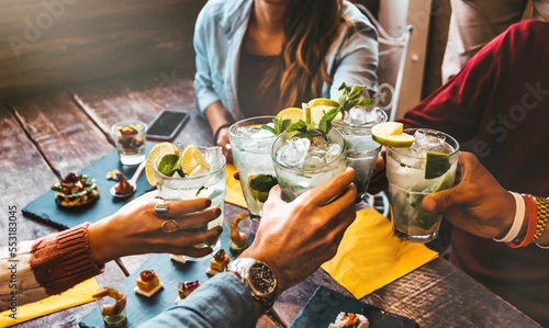 Vászonkép Happy friends celebrating party toasting mojito drinks at cocktail bar restauran